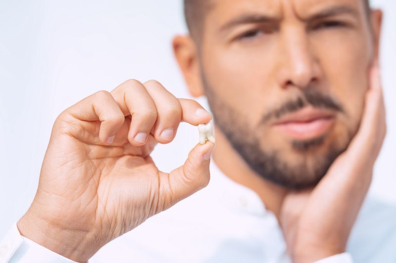 Patient holding pulled tooth